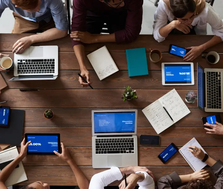 Team working together around a table with reports and devices